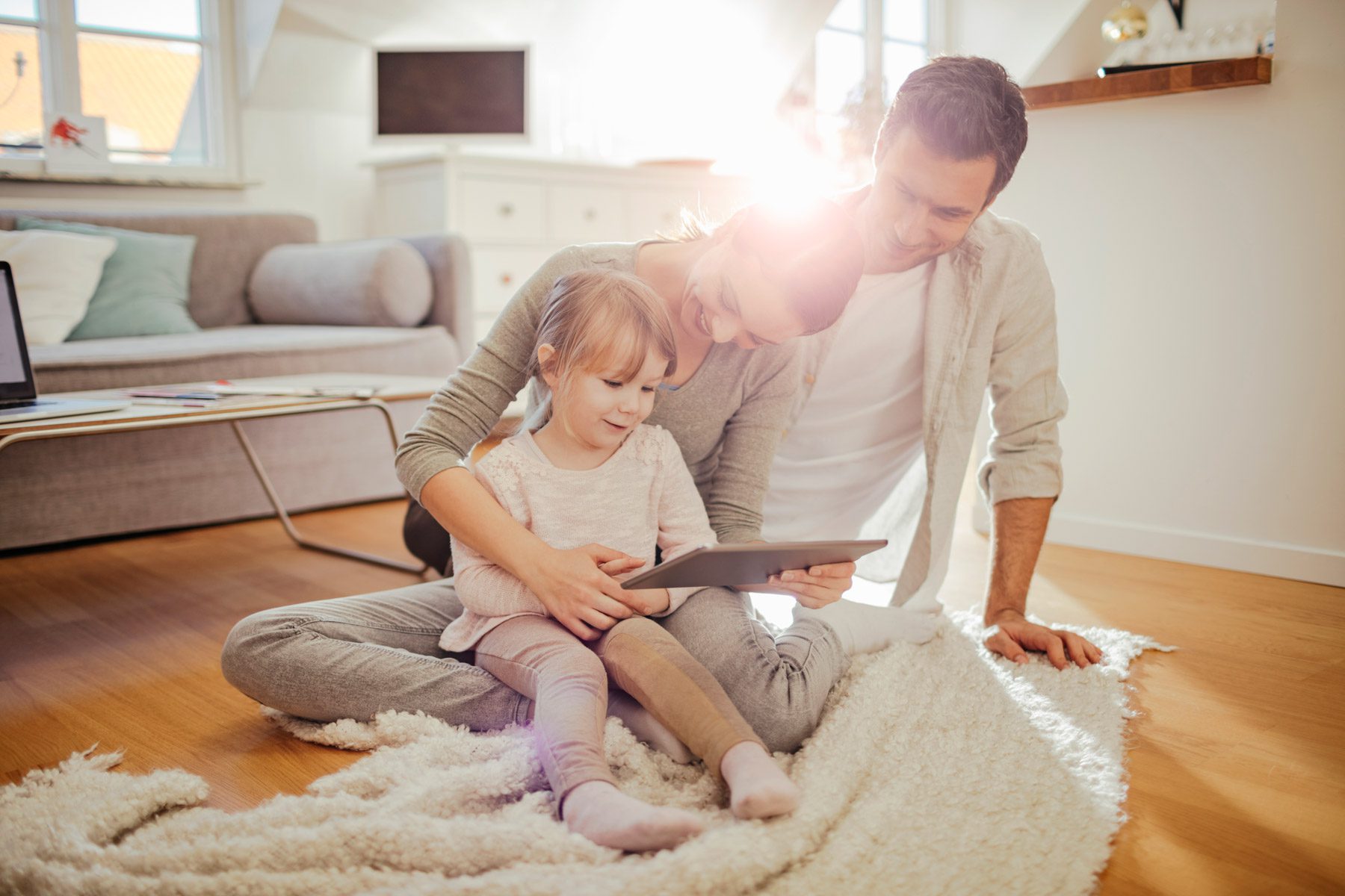 Junge Familie zuhause mit Tablet